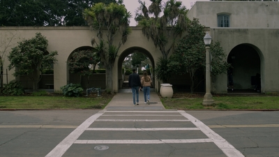 a couple of people walking down a sidewalk