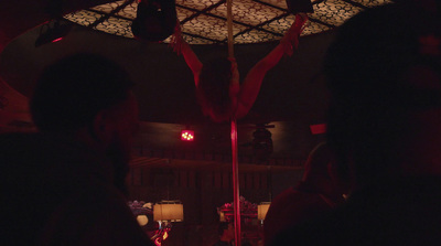 a man is hanging upside down on a pole