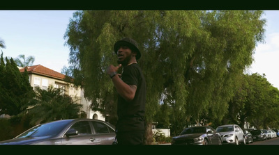 a man standing in front of a tree talking on a cell phone