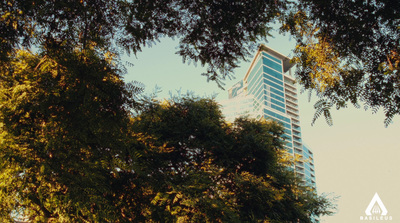 a tall building is seen through the trees