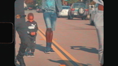 a man walking down a street next to a little boy