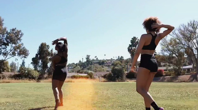 two women in bathing suits playing frisbee in a field