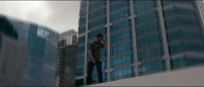 a man standing on top of a building talking on a cell phone