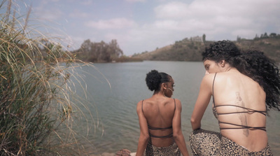 a couple of women standing next to each other near a body of water