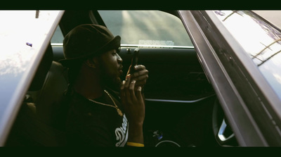 a man sitting in a car using a cell phone