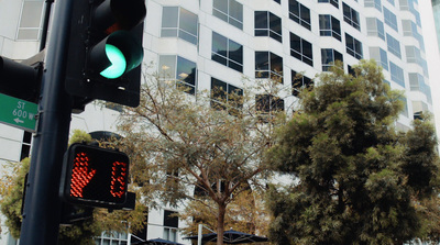 a green traffic light sitting next to a tall building