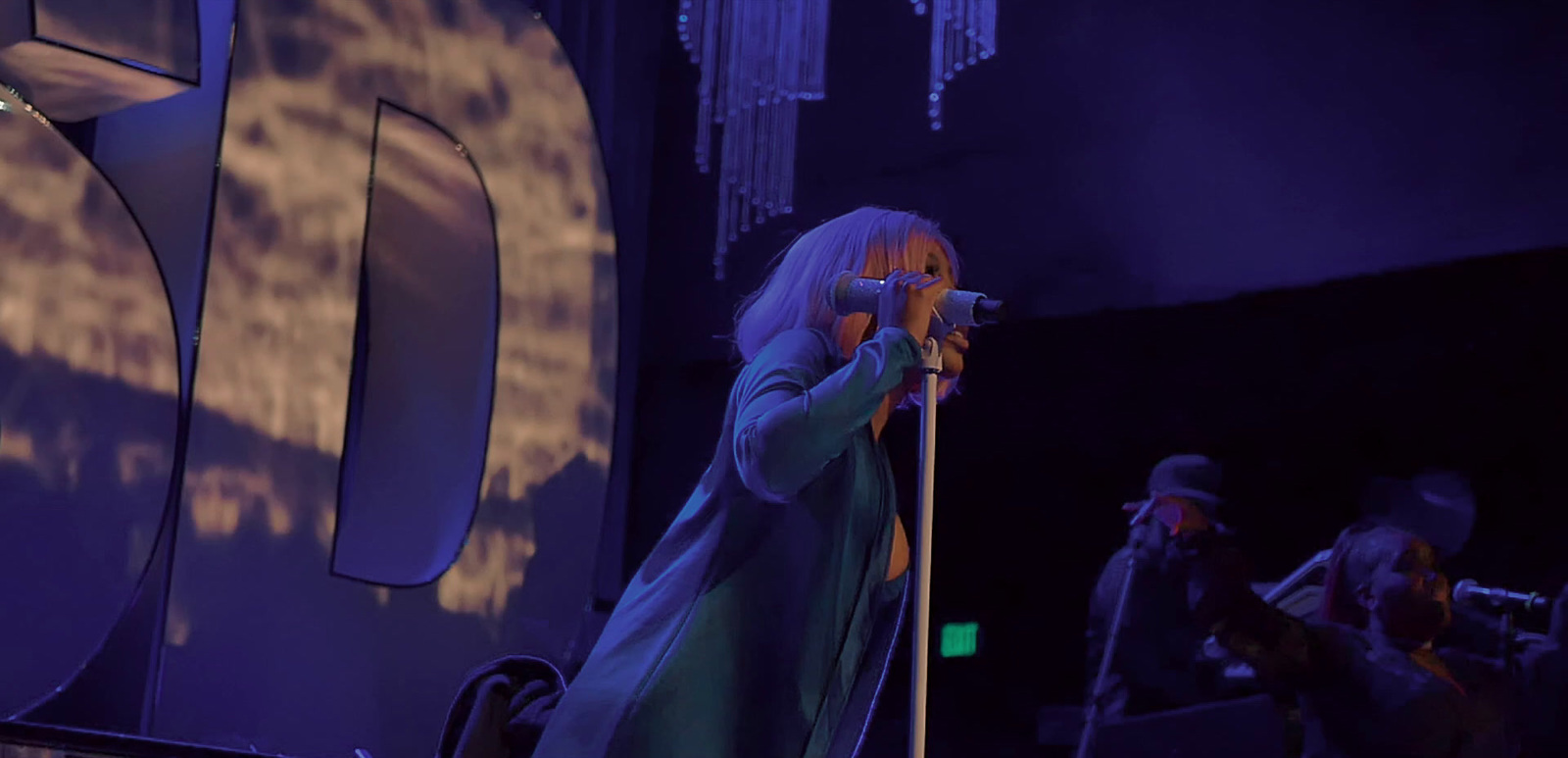 a woman standing on a stage holding a microphone