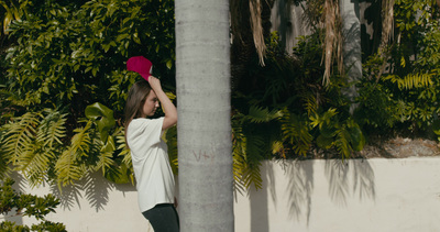 a woman standing next to a pole with a red hat on her head