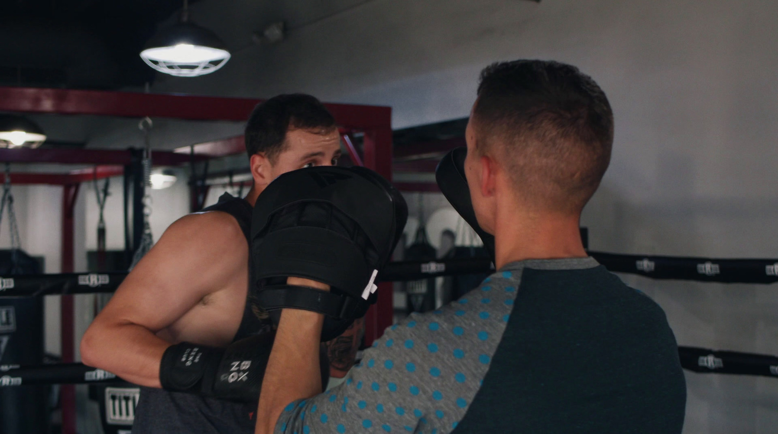 a couple of men standing in a gym