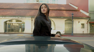 a woman standing next to a car in front of a building