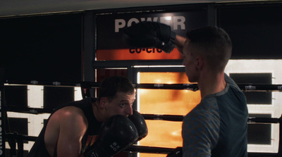 a man standing next to another man in a boxing ring