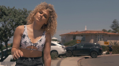 a woman in a crop top is standing on a street corner