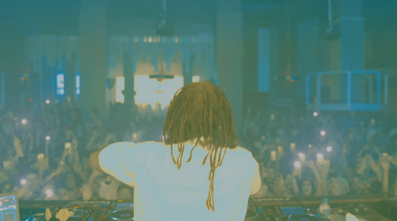 a man with dreadlocks standing in front of a crowd