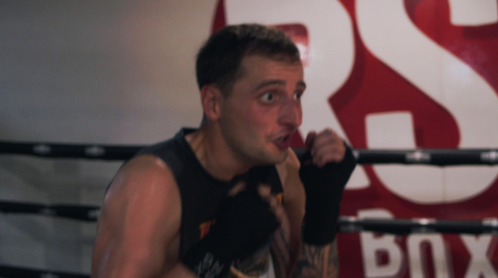 a man standing in a boxing ring holding a boxing glove