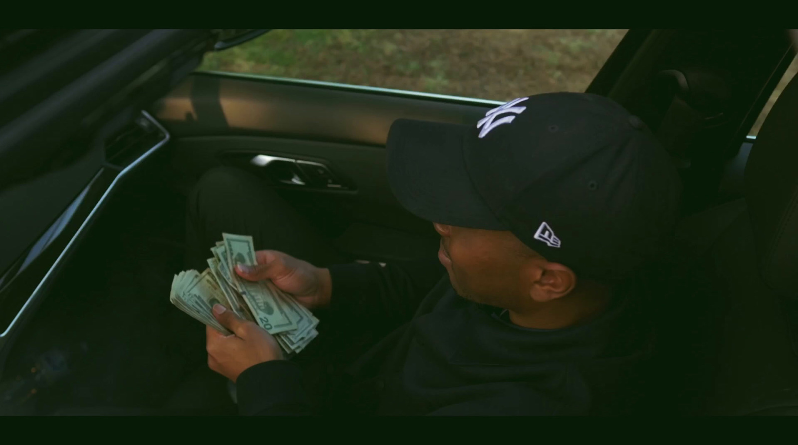 a young boy sitting in a car holding money