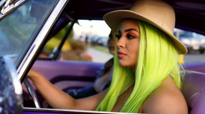 a woman with green hair sitting in a car