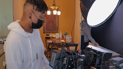 a man wearing a face mask in front of a camera