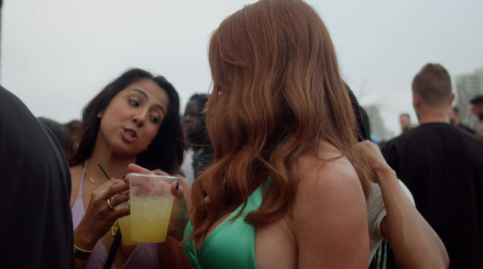 a woman in a green dress holding a drink