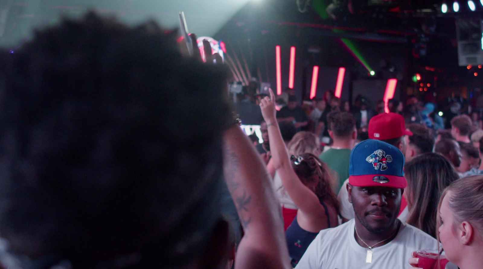 a crowd of people at a concert with a man wearing a red and blue hat