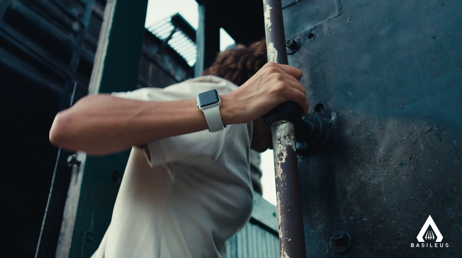 a man in white shirt holding onto a metal door