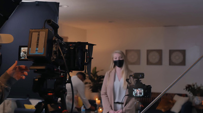 a woman wearing a face mask in front of a camera