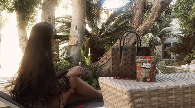 a woman sitting at a table with a purse