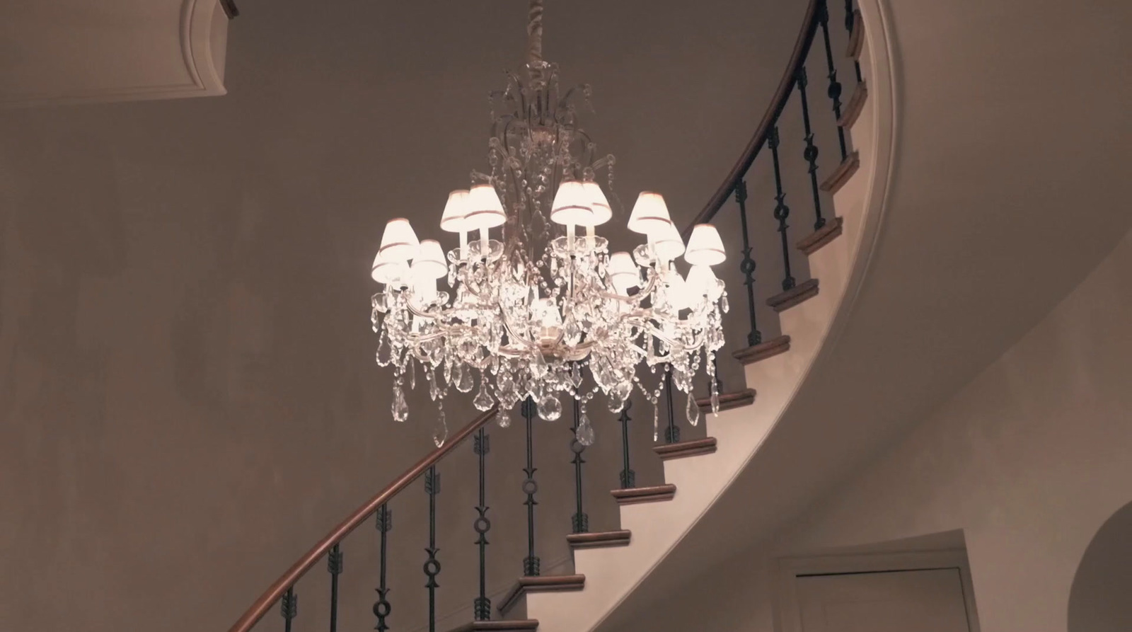 a chandelier hanging from the side of a staircase