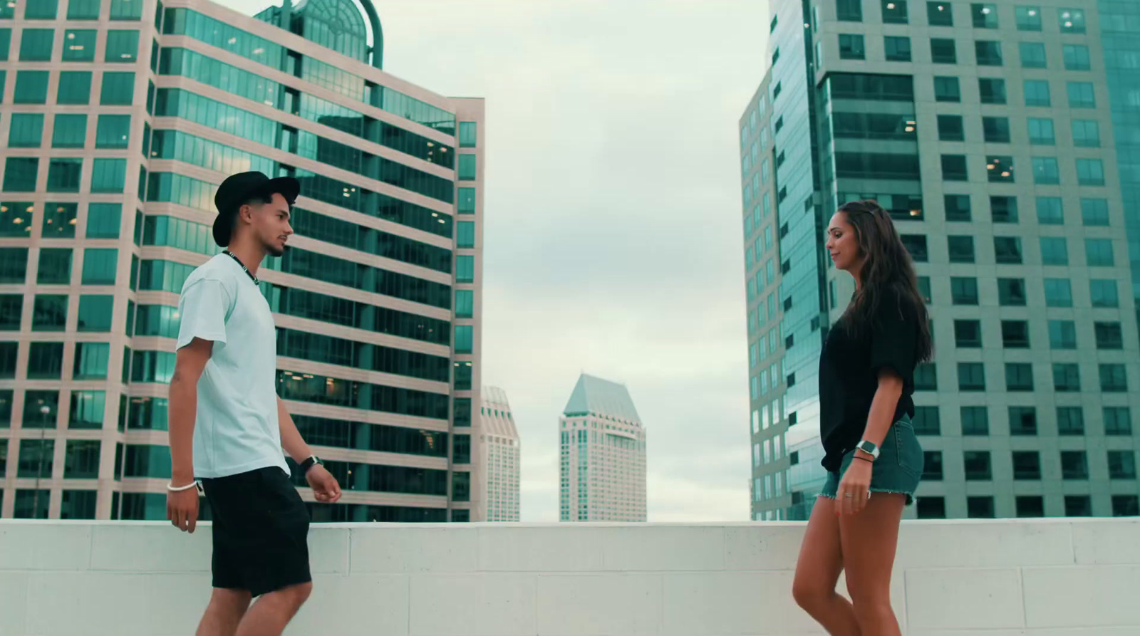 a man and a woman standing on top of a roof