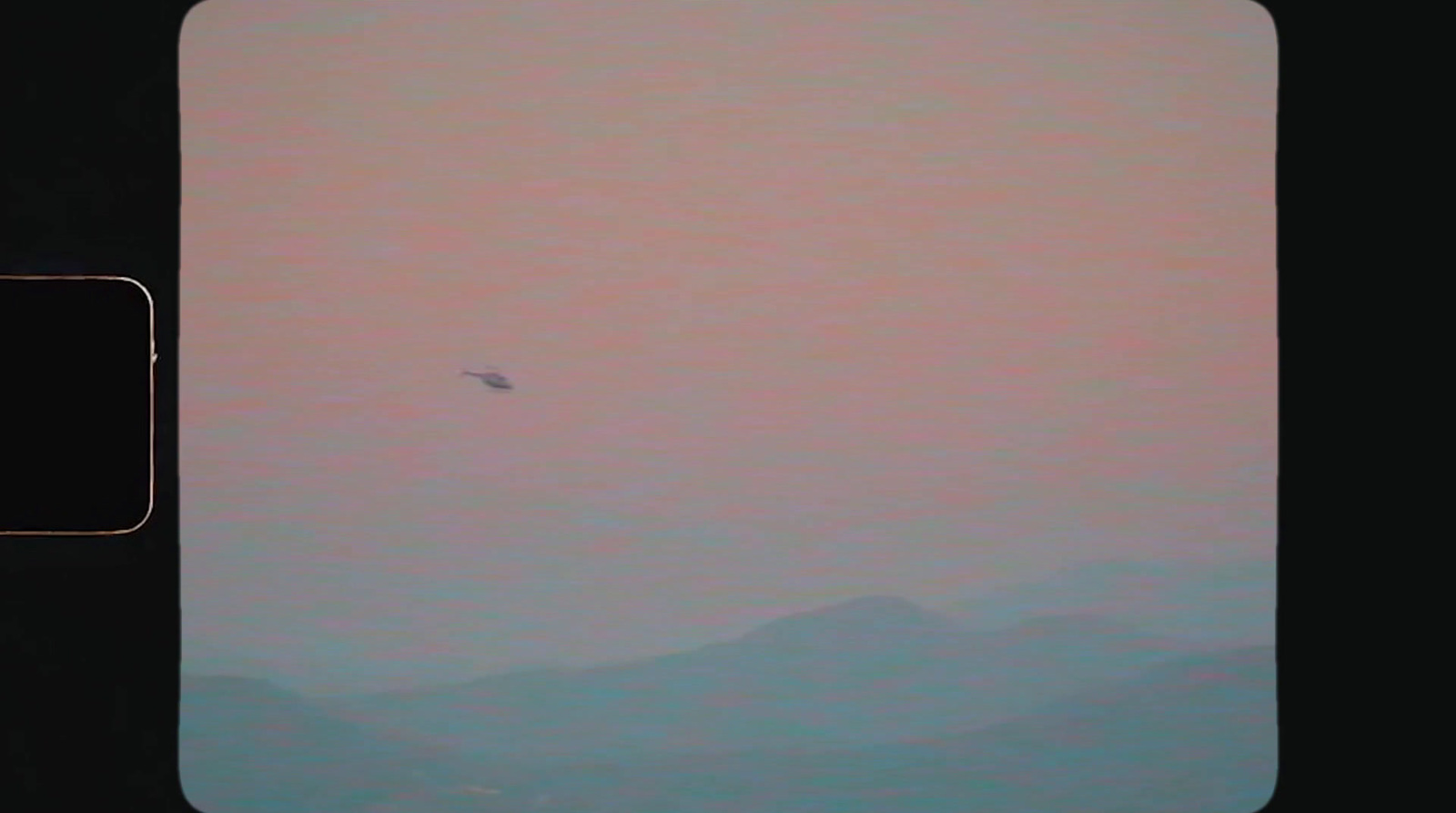 a small airplane flying through a pink sky