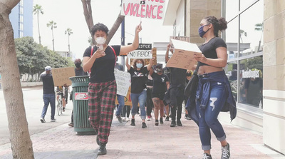 a group of people walking down a street holding signs