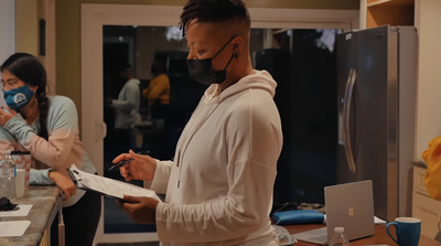 a man wearing a face mask while standing in a kitchen