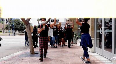 a group of people walking down a street holding signs