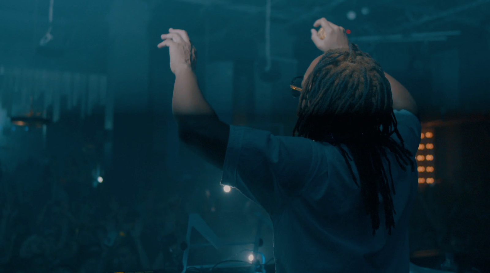 a man with dreadlocks standing in front of a crowd