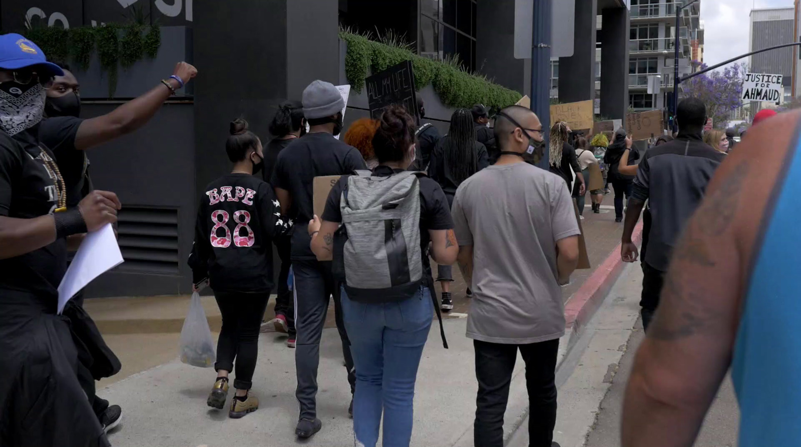 a group of people walking down a sidewalk