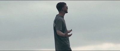 a man standing in front of a cloudy sky