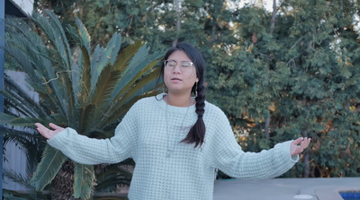 a woman standing in front of a palm tree