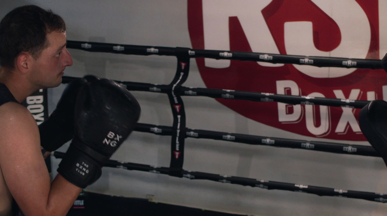 a man standing next to a punching bag