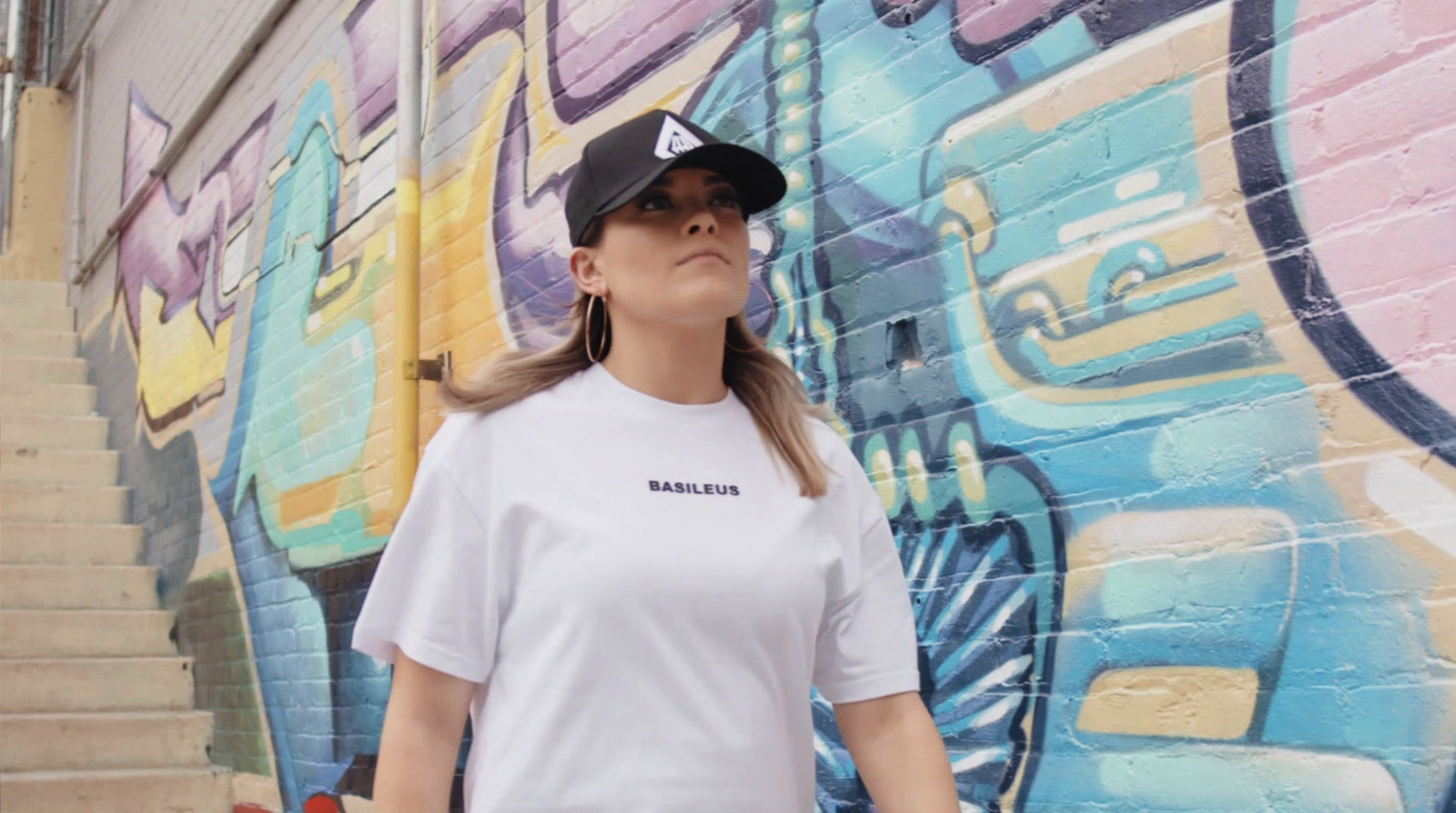 a woman standing in front of a graffiti wall