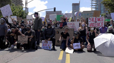 a group of people holding signs and umbrellas