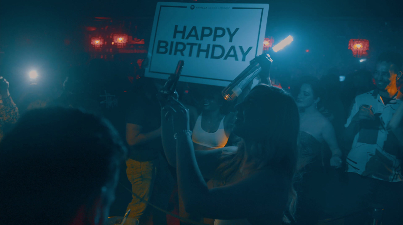 a woman holding a sign that says happy birthday