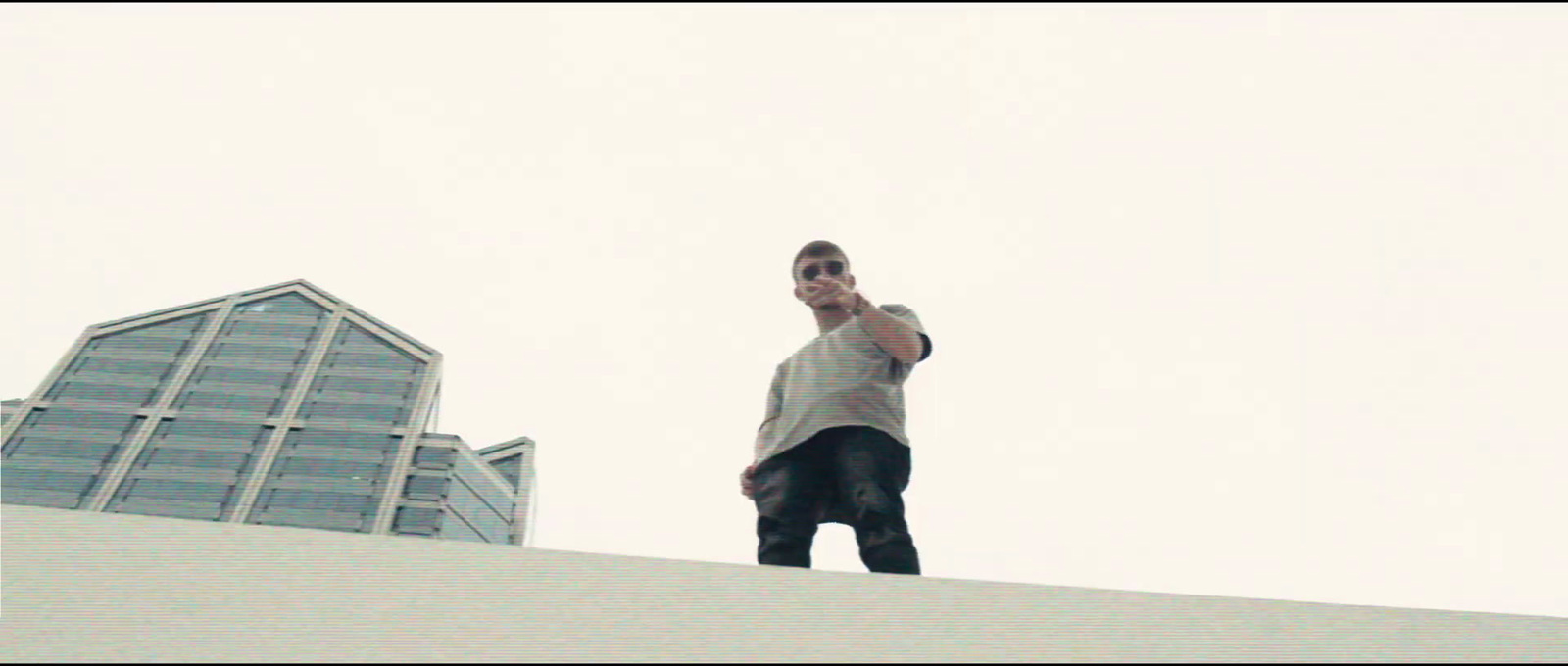 a man standing on top of a roof talking on a cell phone