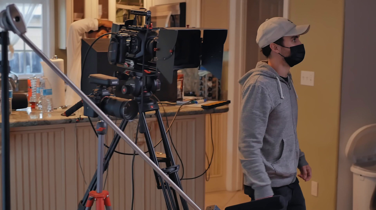 a man wearing a face mask standing in front of a camera