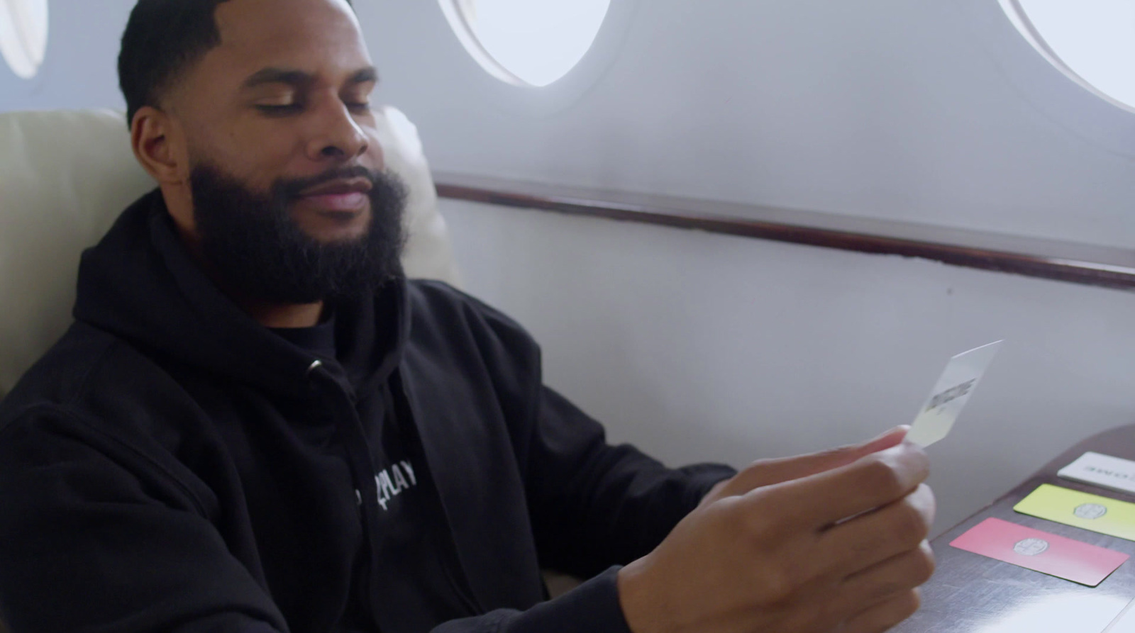 a man sitting in an airplane looking at his cell phone