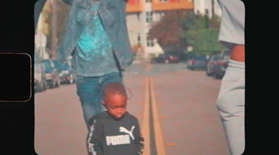 a young boy walking down a street next to a man