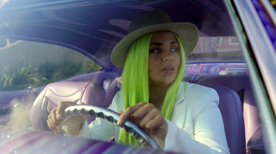 a woman with green hair sitting in a car