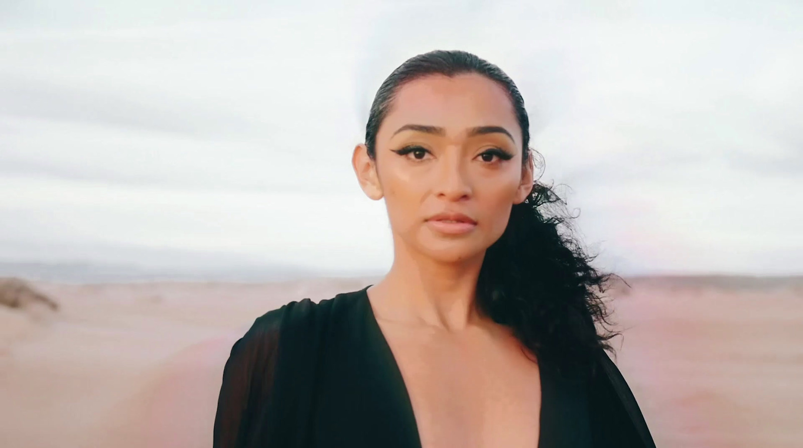 a woman in a black dress posing for a picture