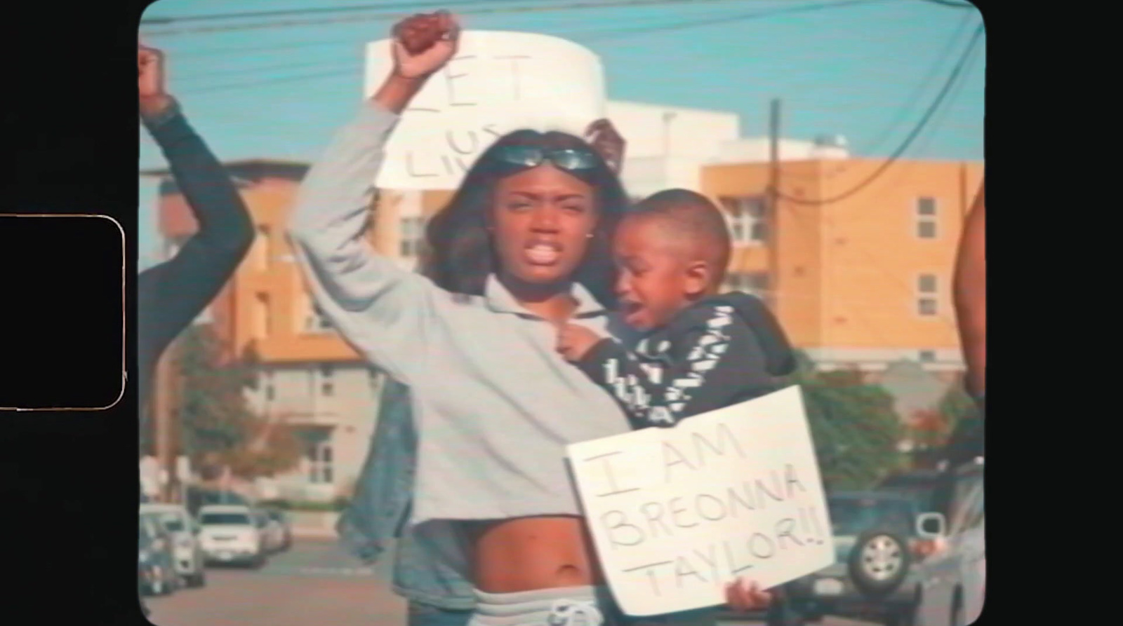 a woman holding a child and a sign