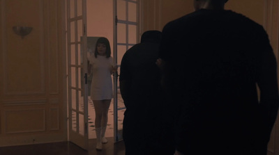 a woman in a white dress standing in a doorway