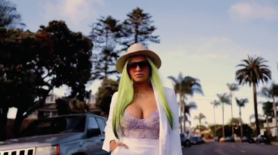 a woman with green hair wearing a hat and sunglasses