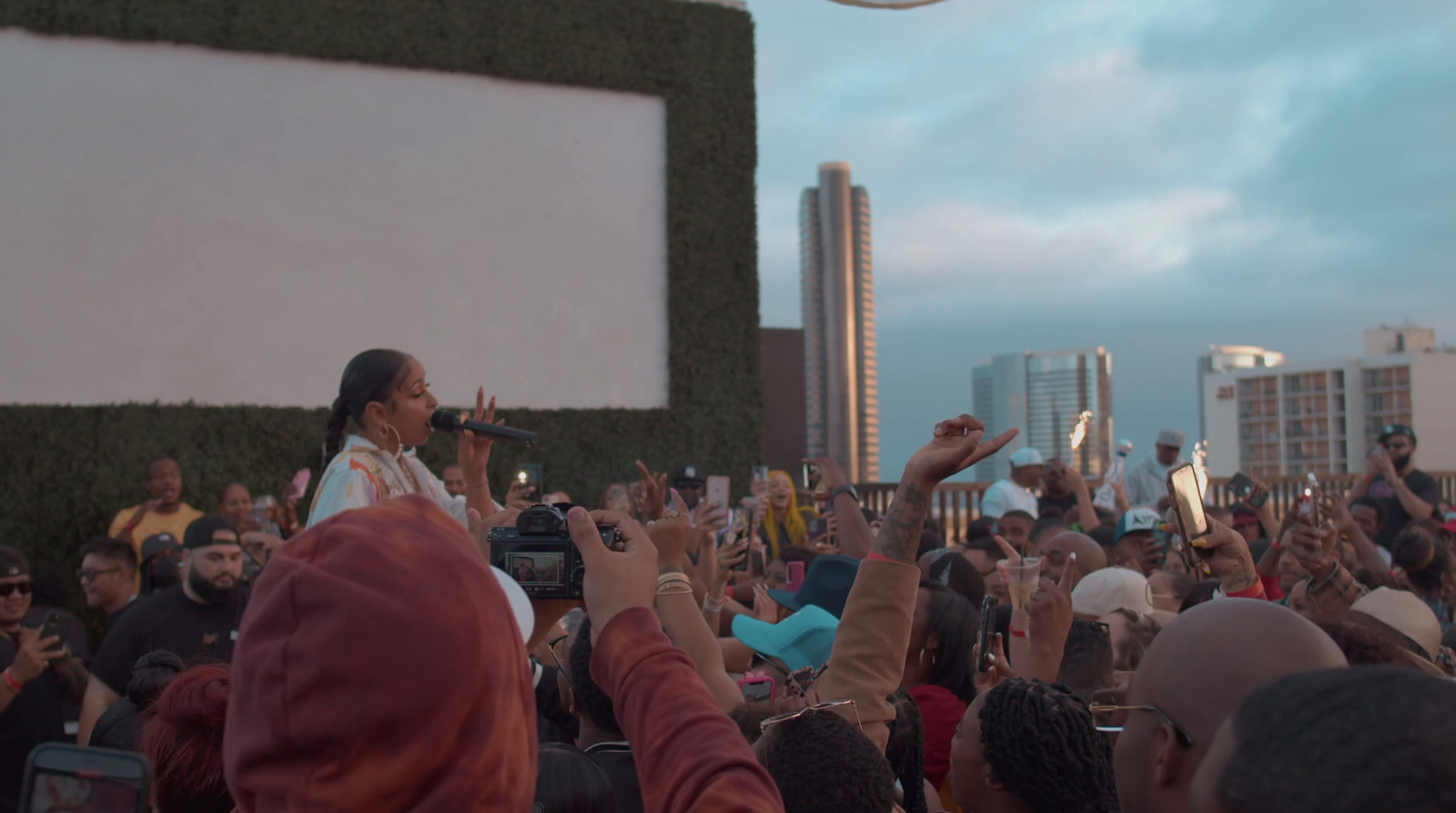 a crowd of people standing around a man on a stage